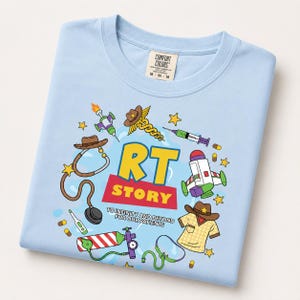 May include: A light blue t-shirt featuring a graphic print with the text RT STORY TO INFINITY AND BEYOND FOR OUR PATIENTS. The design includes illustrations of a stethoscope, a cowboy hat, a space toy, a syringe, a thermometer, and medical equipment.