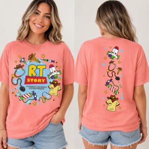 May include: A coral-colored short-sleeve t-shirt featuring a graphic print. The front displays the text RT STORY TO INFINITY AND BEYOND FOR OUR PATIENTS surrounded by illustrations of medical equipment and a cowboy hat. The back shows a vertical design.