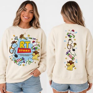 May include: A cream-colored crewneck sweatshirt featuring a graphic print. The front displays the text RT STORY with illustrations of a stethoscope, oxygen tank, syringe, and cowboy shirt. The back shows a vertical arrangement of these same icons.