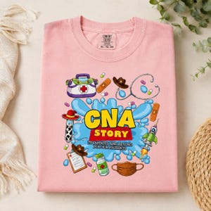 May include: A light pink t-shirt featuring a graphic print with the text CNA STORY TO INFINITY AND BEYOND FOR OUR PATIENTS. The design includes medical items like a stethoscope, a clipboard, a face mask, and pills, alongside toy-themed elements.