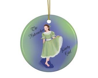 May include: Round Christmas ornament with a green and blue background. The ornament features an illustration of a woman in a green dress with the text "The Nutcracker Party Girl". The ornament is hanging by a gold string.