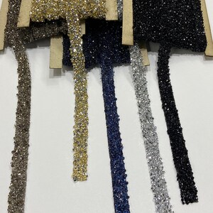 May include: Assortment of six different colored beaded trims. The trims are made of small, sparkly beads in silver, gold, black, navy blue, and light blue.
