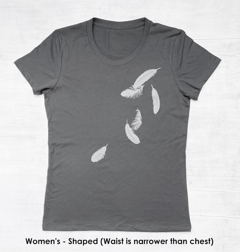 May include: A charcoal gray t-shirt with a design of white feathers falling on the right side of the shirt.
