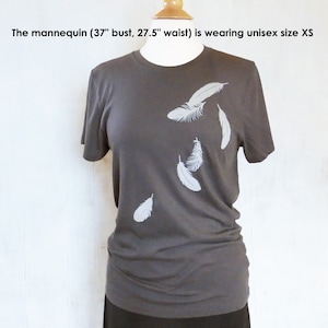 May include: A charcoal gray t-shirt with a white feather design. The mannequin is wearing a size XS.