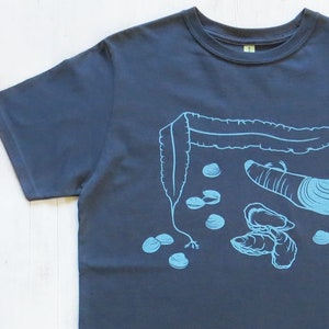 May include: A dark blue t-shirt with a light blue design of seaweed, clams, and oysters.