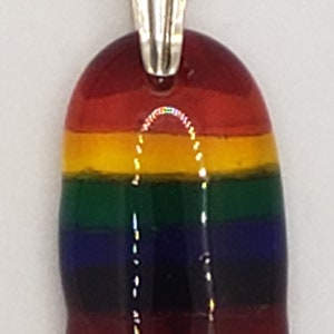 May include: A rainbow glass pendant with a silver bail. The pendant is made of layered glass in the colours of the rainbow, with red, orange, yellow, green, blue, and purple stripes.