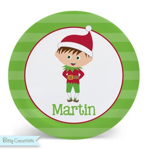 May include: A green and white striped plate with a red and white elf illustration and the name "Martin" in red text.