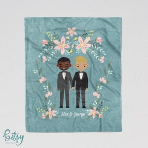 May include: A teal blue fleece blanket with a floral wreath design. Two cartoon figures of grooms in black tuxedos stand in the center of the wreath. The text "Alex & George" is printed below the figures.