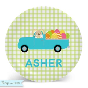 May include: A green and white checkered plate with a blue truck carrying a bunny and colorful Easter eggs. The truck has the name "ASHER" written on the bottom.