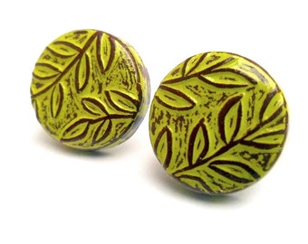 May include: A pair of lime green and brown round earrings with a leaf pattern.
