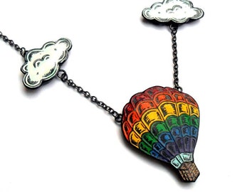 May include: A rainbow hot air balloon charm necklace with two white cloud charms. The necklace is made of black metal chain.