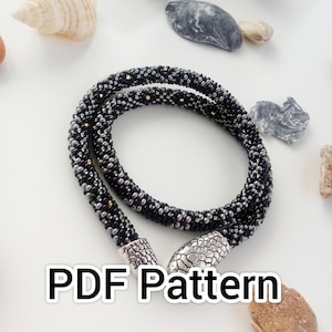 May include: A black and silver beaded necklace with gold accents and silver snake-shaped end caps. PDF Pattern.