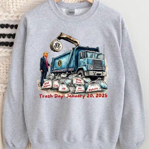 a gray sweatshirt with a picture of a man standing next to a dump truck