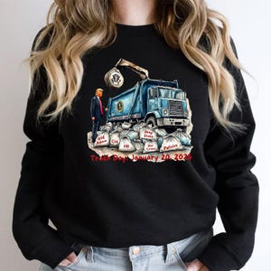 a woman wearing a black sweatshirt with a blue dump truck on it