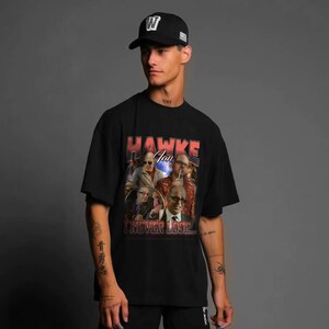 a man wearing a black hat and a black t - shirt