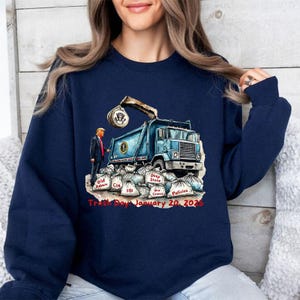 a woman wearing a blue sweatshirt with a dump truck on it