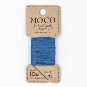 May include: A blue thread spool for hand stitching, branded "MOCO for hand stitch" and made of 100% polyester. The label shows 10m of thread and colour code 74. The thread is wound on a cardboard spool.