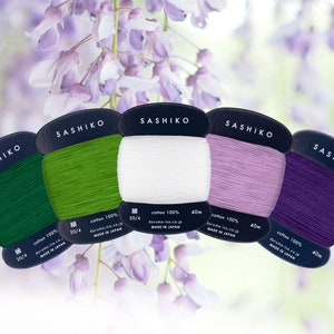 May include: Five spools of 20/4 cotton thread in green, white, lavender, and purple. Each spool is labelled "SASHIKO" and "cotton 100%" with the brand name "daruma-ito.co.jp" and "MADE IN JAPAN".