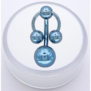 May include: A blue belly button ring with a curved top and a vertical bar connecting to three spherical beads. The ring is displayed on a white surface inside a clear container.