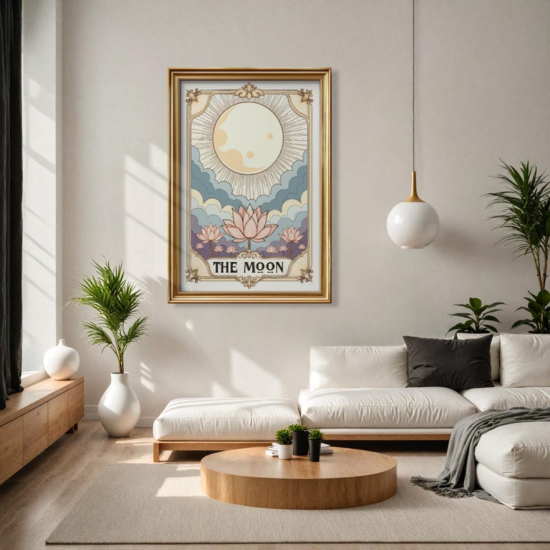 May include: A gold framed print of a tarot card depicting the moon with a large, yellow moon and three pink lotus flowers. The card is titled "THE MOON".