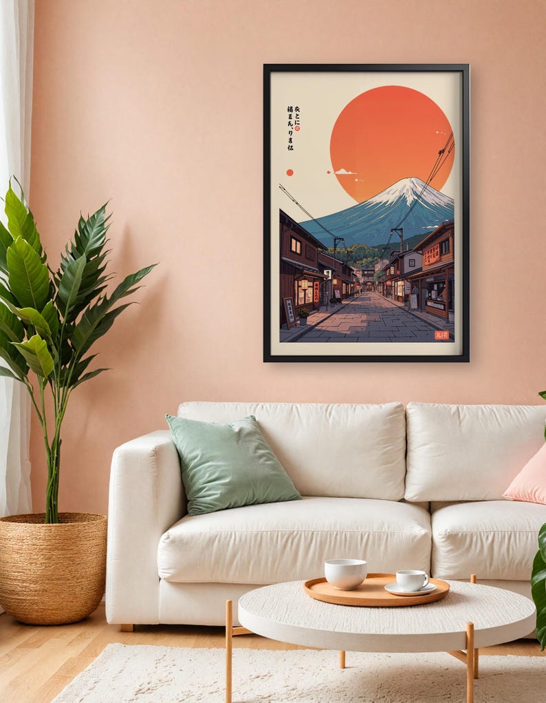 Pode incluir: Uma impress&atilde;o emoldurada de uma cena de rua japonesa com o Monte Fuji ao fundo. O sol se p&otilde;e atr&aacute;s da montanha, lan&ccedil;ando um brilho quente sobre a cena. O texto na impress&atilde;o diz "峰と雲に抱かれた街".