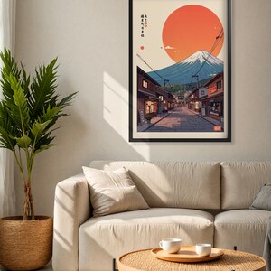 Pode incluir: Uma impress&atilde;o emoldurada de uma paisagem urbana japonesa com o Monte Fuji ao fundo. O sol se p&otilde;e atr&aacute;s da montanha, lan&ccedil;ando um brilho laranja quente sobre a cena. A impress&atilde;o apresenta texto japon&ecirc;s que diz "ここに住みたい", que se traduz como "Quero morar aqui".