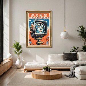 May include: Framed vintage-style poster featuring a retro-futuristic image of a woman's face inside a television screen. The artwork has a gold frame and includes Japanese text at the top. The color palette includes orange, blue, and white.