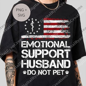 May include: Black t-shirt with a distressed American flag design. The flag features a medical symbol and the words "EMOTIONAL SUPPORT HUSBAND" and "DO NOT PET" in white lettering. Includes a "PNG + SVG" graphic.