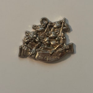 May include: Silver charm featuring a group of frogs with the inscription "De Efteling" on a banner.