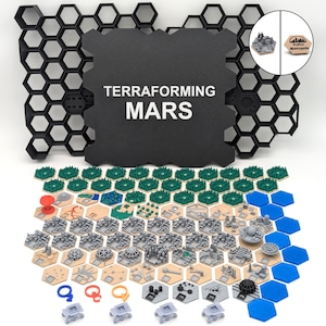 Könnte beinhalten: Terraforming Mars Brettspiel mit einem schwarzen Spielbrett, grünen und blauen sechseckigen Spielsteinen und kleinen Plastikfiguren. Das Spiel enthält einen schwarzen sechseckigen Spielsteinhälter mit dem aufgedruckten Text "Terraforming Mars".