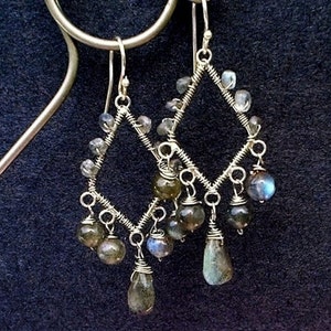 May include: Silver wire earrings with a diamond shape design and dangling labradorite stones.