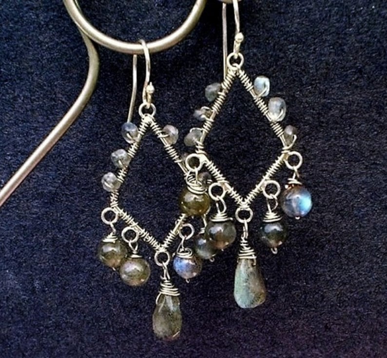 May include: Silver wire earrings with a diamond shape design and dangling labradorite stones.
