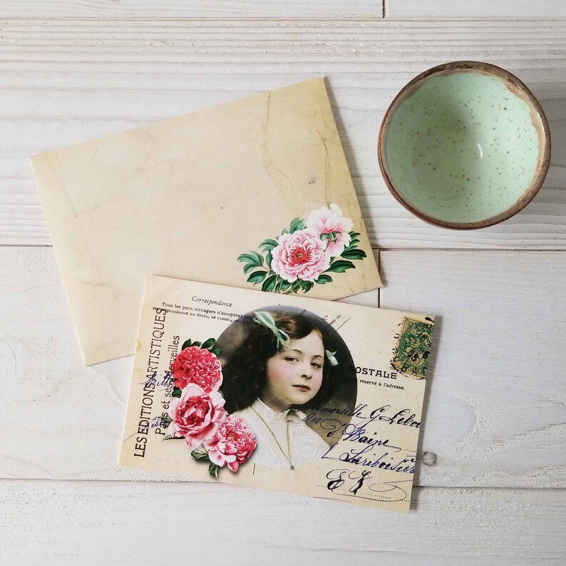 May include: Vintage postcard featuring a young girl with a floral crown and a pink flower bouquet. The postcard has a faded, antique look and includes the text "LES EDITIONS ARTISTIQUES Paris et ses Merveilles Correspondance OSTALE".