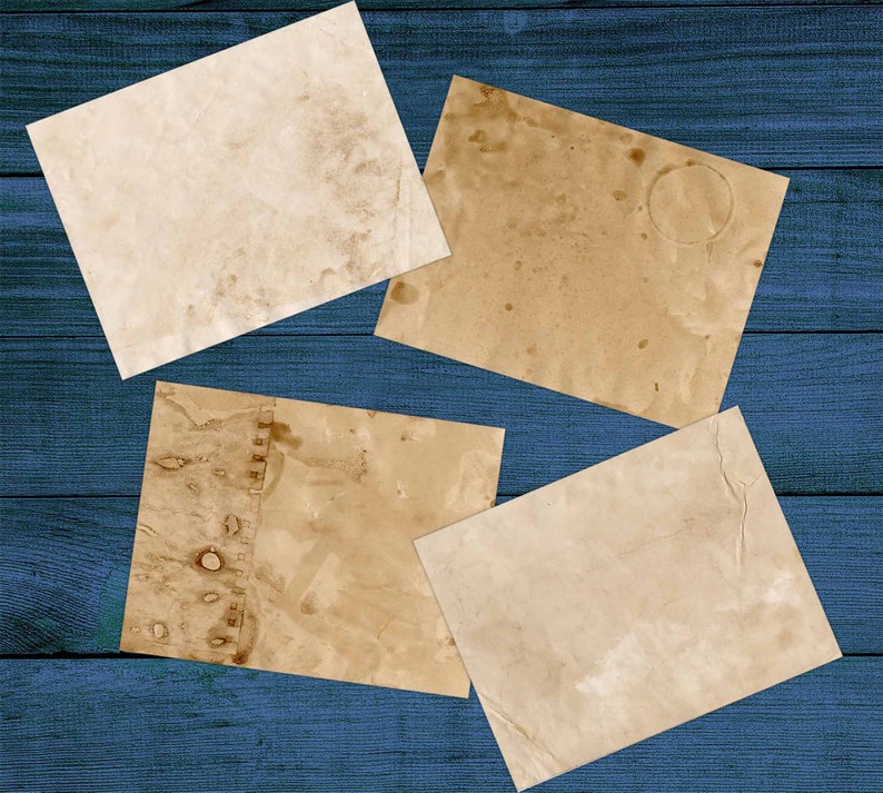 Puede incluir: Cuatro hojas de papel envejecido, de color blanco roto, con manchas marrones y pliegues. El papel est&aacute; dispuesto sobre una superficie de madera azul.
