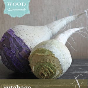 Könnte beinhalten: Zwei handgefertigte Stoff-Rüben, eine lila und eine grüne, mit dem Text "rutabaga a sewing pattern" und "ANN WOOD handmade" auf dem Bild.