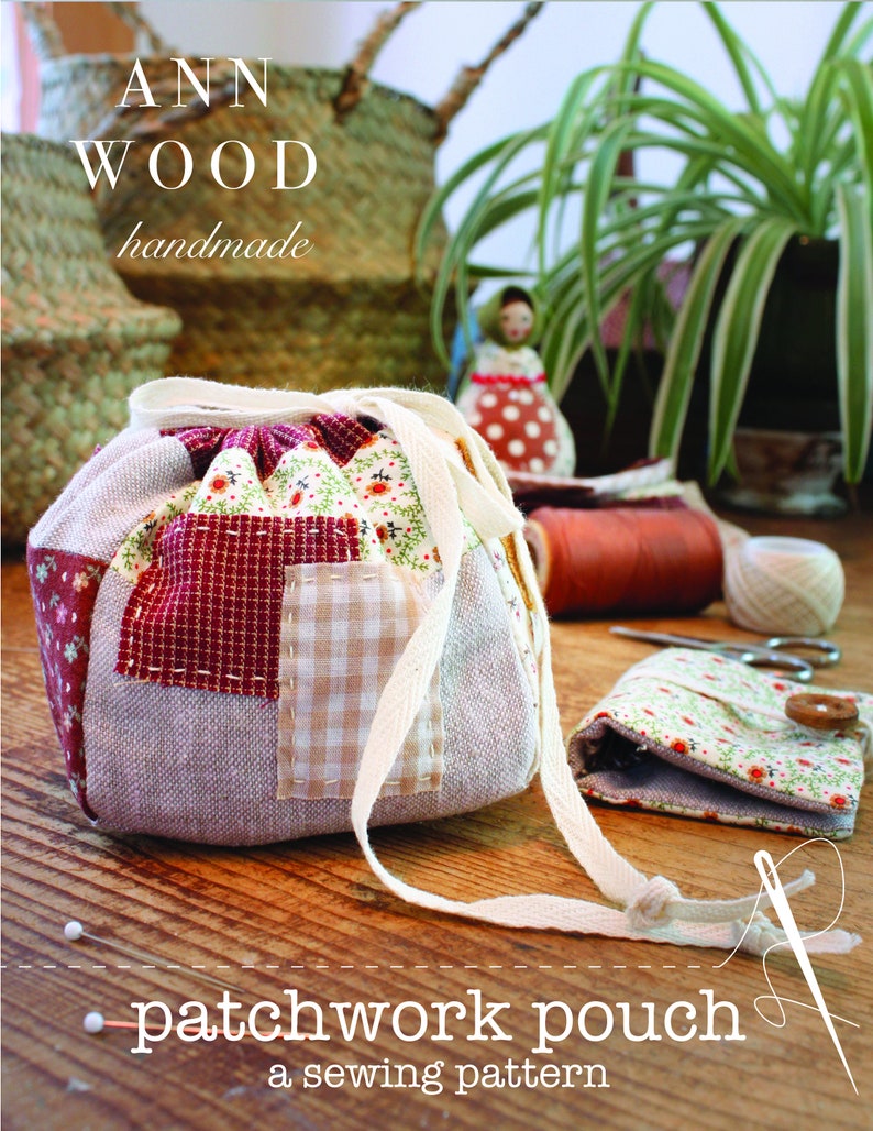 May include: A patchwork pouch with a drawstring closure, featuring a mix of patterned fabrics in red, beige, and floral prints. The text "ANN WOOD handmade" and "patchwork pouch a sewing pattern" are visible. A small floral pouch and sewing supplies are also present.