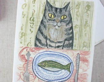 Puede incluir: Una ilustración de acuarela de un gato atigrado gris sentado frente a un plato con un pez encima. El gato tiene ojos amarillos y un pecho blanco. El plato es azul y blanco con un borde decorativo. El pez es verde y tiene una barriga blanca.