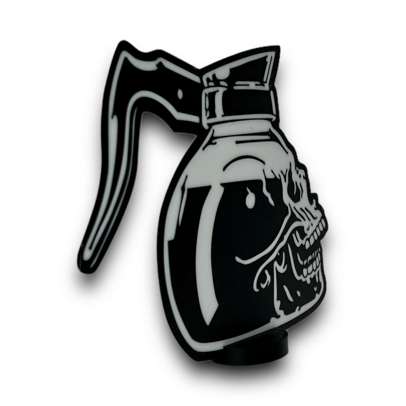 Pode incluir: Ilustra&ccedil;&atilde;o em preto e branco de um bule de caf&eacute; em forma de caveira. O bule tem uma al&ccedil;a e um bico. A caveira &eacute; detalhada com um nariz, olhos e dentes.