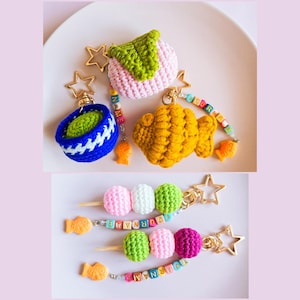 Może przedstawiać: Breloki na klucze wykonane na szydełku w kształcie japońskich przekąsek. Breloki zawierają zieloną herbatę w lodach, rybę taiyaki, mochi i dango na patyku. Każdy brelok ma złoty charms w kształcie gwiazdki i koralikową zawieszkę z tekstem "YOUR NAME".