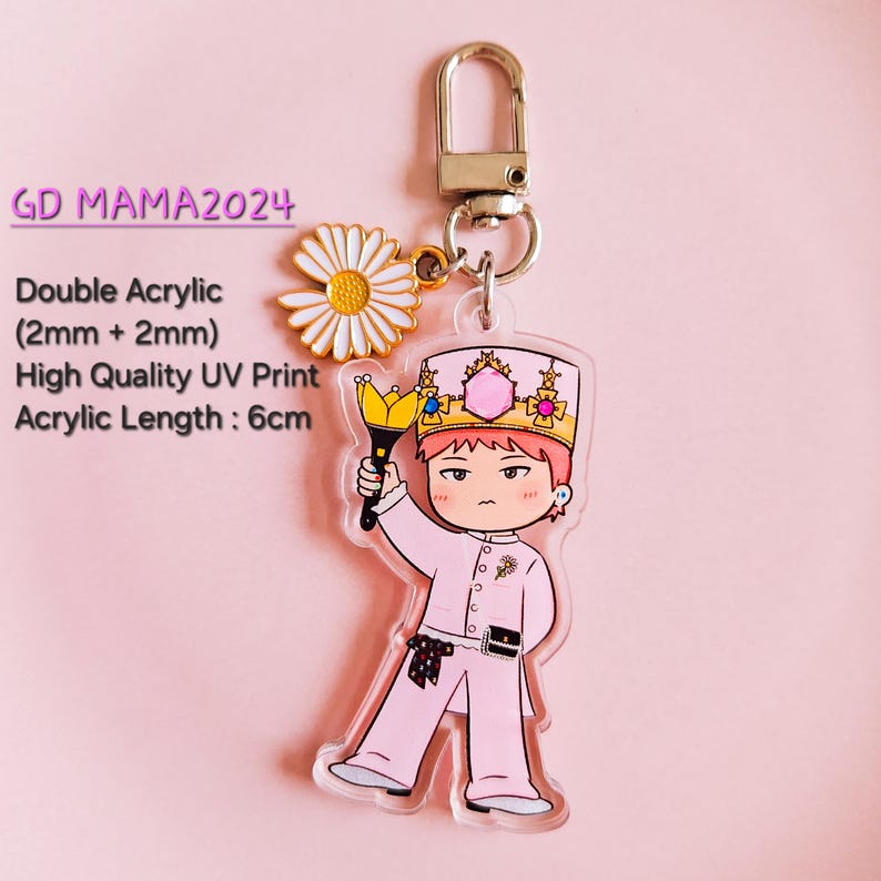 May include: A pink acrylic keychain featuring a cartoon character wearing a crown and holding a scepter. The keychain includes a daisy charm and a metal clasp. The text "GD MAMA2024" is visible. Acrylic length is 6cm.