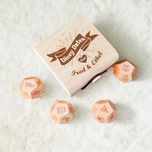 a wooden dice box with four wooden dices next to it
