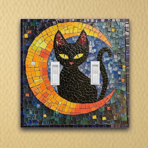May include: A black cat silhouette sitting on a crescent moon, surrounded by a mosaic of blue, green, yellow, and orange tiles. The mosaic is a light switch cover.