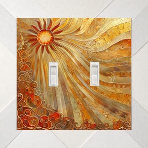 May include: A double light switch wall plate featuring a vibrant sun graphic with radiating golden and orange beams. The design includes intricate swirling patterns in the lower left corner and two white toggle switches centered.