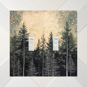 May include: A double light switch cover plate featuring a printed forest scene with dark green pine trees against a pale yellow sky filled with white circular dots representing falling snow. Two white toggle switches are centered on the plate.