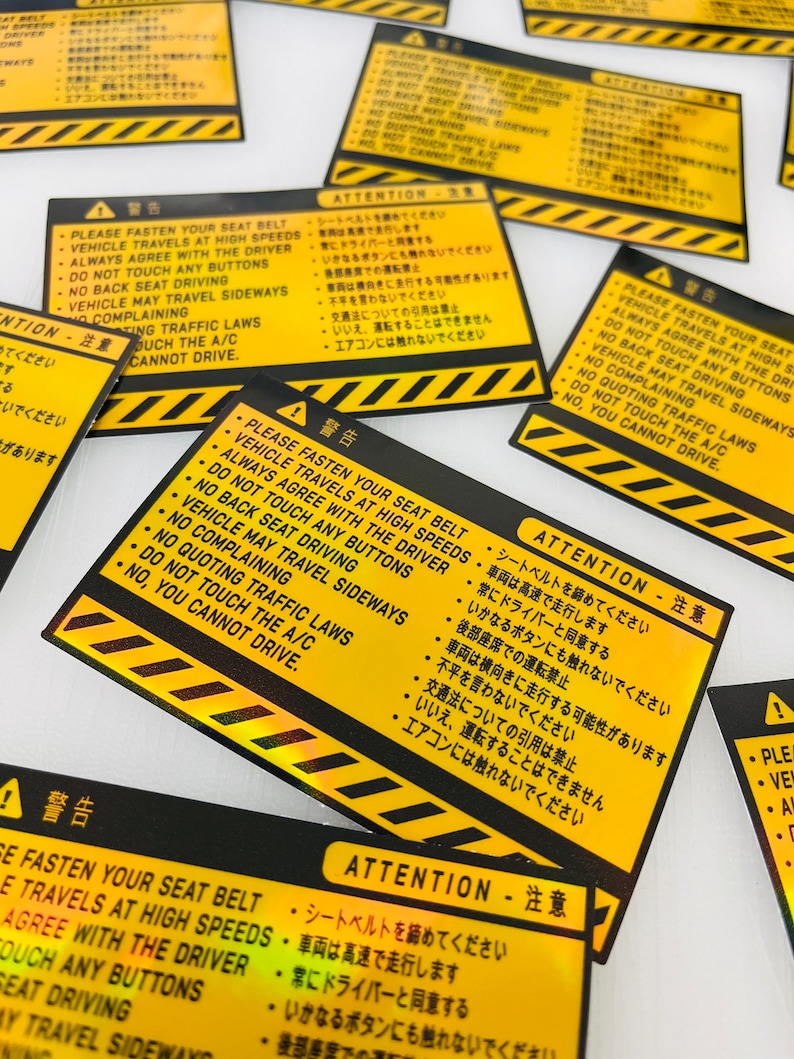 May include: Yellow and black warning stickers with the text "PLEASE FASTEN YOUR SEAT BELT" and "ATTENTION" in English and Japanese. The stickers have a black and yellow striped border.