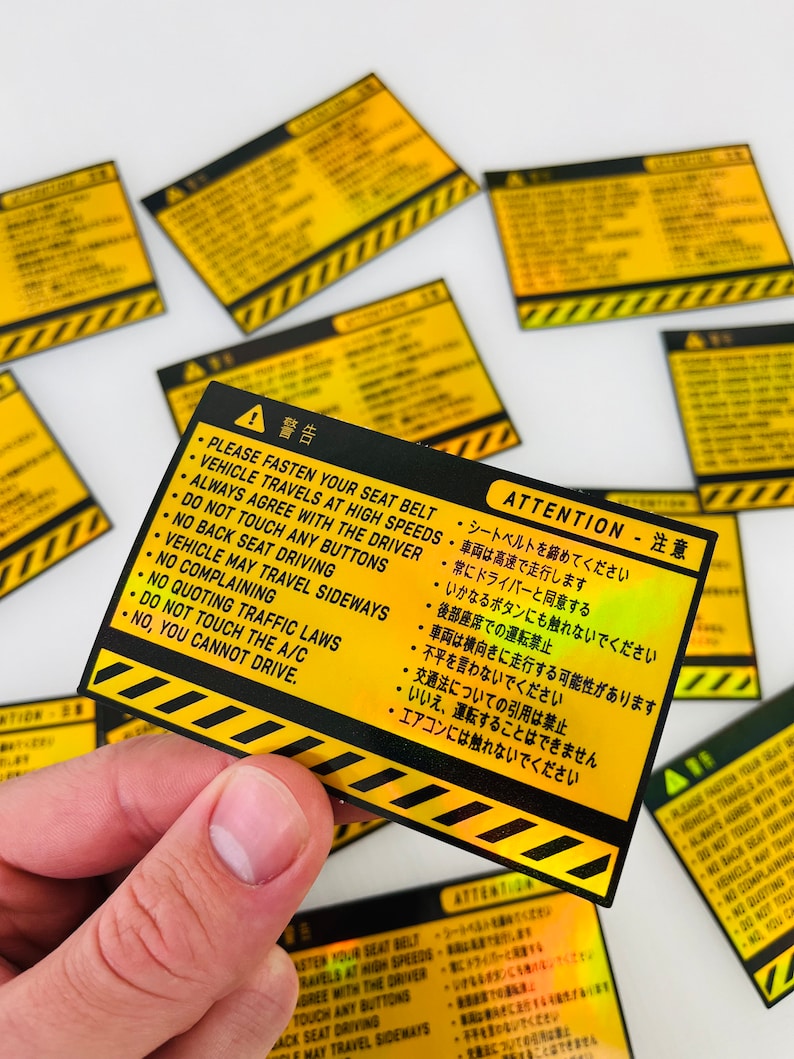 May include: Yellow and black warning sticker with the text "ATTENTION - 注意" and a list of rules in both English and Japanese. The sticker has a holographic finish.