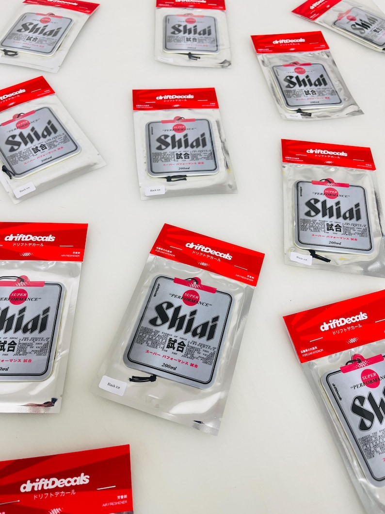 May include: A set of 10 silver car air fresheners with a black and white design. The air fresheners feature the text "Shiai" and "試合" in Japanese. The air fresheners are packaged in clear plastic bags with red and white labels that say "driftDecals" and "ドリフトデカール".