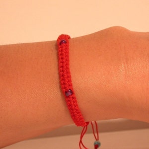 Rött snörearmband (med pärlor)