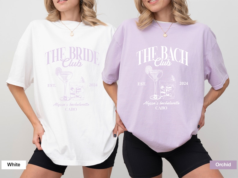 K&ouml;nnte beinhalten: Zwei wei&szlig;e T-Shirts mit einem lilafarbenen Design. Der Text auf den Shirts lautet "The Bride Club" und "The Bach Club". Die Shirts zeigen au&szlig;erdem ein Cocktailglas mit einer Limettenscheibe und Eisw&uuml;rfeln. Der Text "Est. 2024" und "Alyssa's Bachelorette Cabo" befindet sich ebenfalls auf den Shirts.