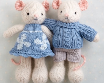 May include: Two knitted mouse toys, one wearing a blue dress with white accents and the other wearing a blue sweater and grey pants.